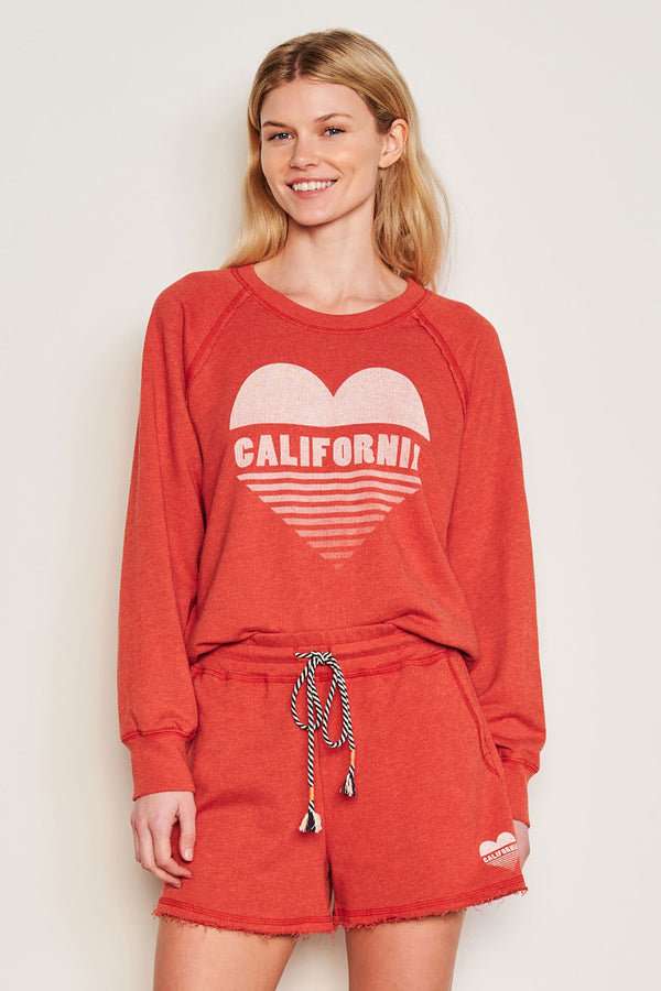 Sundry Cali Heart Raglan Sweatshirt in Burnt Red-3/4 view (model is smiling)