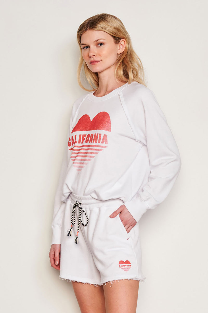 Sundry Cali Heart Raglan Sweatshirt in Optic White-side view model has her hands in her pockets